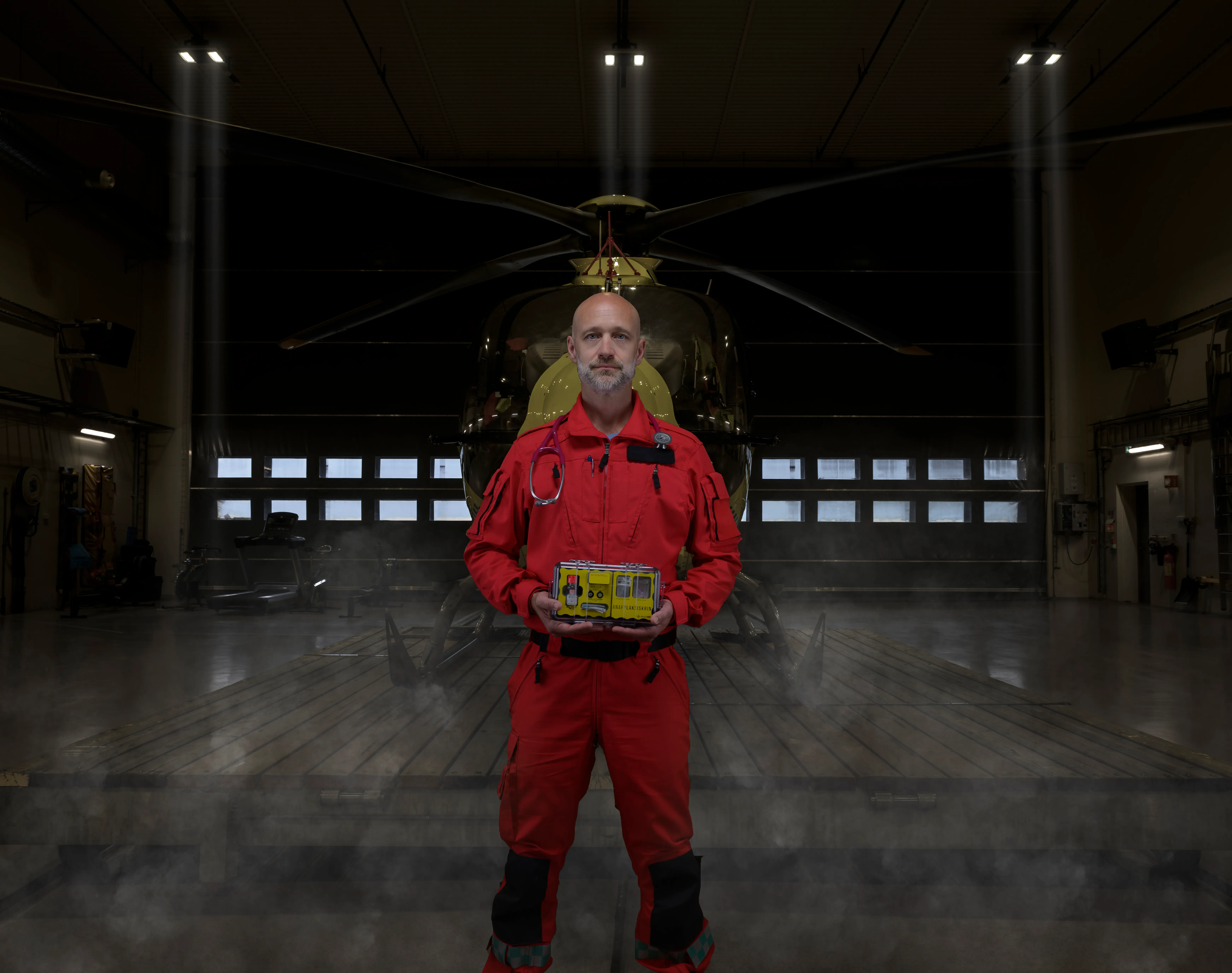 Gregers Halvorsen in a flight suit in front of the air ambulance, with an EmendaKit anaphylaxis kit